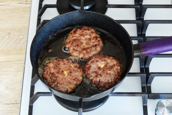 Heat a frying pan over medium heat. Optionally, add a little vegetable oil, though the fat released during the frying of minced meat and bacon is generally sufficient. Fry the cutlets on both sides until they achieve a golden brown color.


