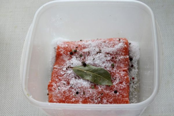Sprinkle peppercorns and bay leaves over the fish.


