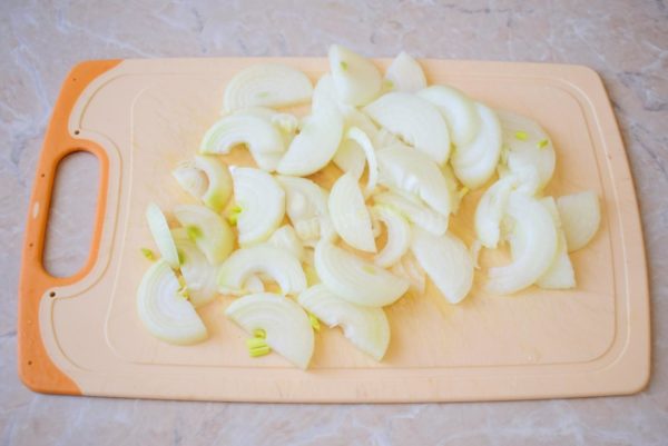 Peel and rinse the onion in cold water to remove impurities. Cut the peeled onion into half rings. It's not necessary to finely chop the onion since it will be boiled during stewing.


