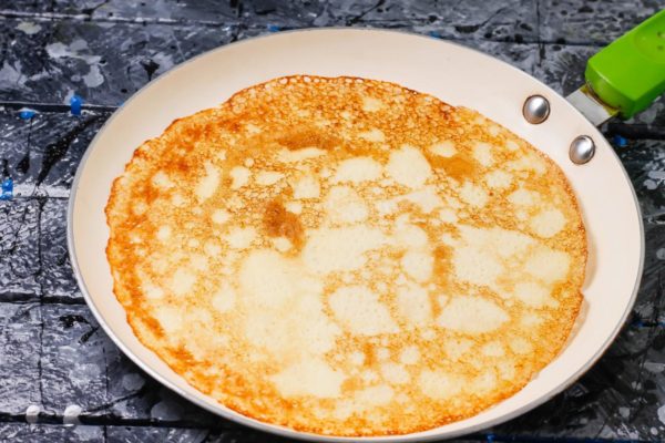 Warm up the pancake pan, brush it with vegetable oil, and warm it up a little more. Pour a portion of the dough into a frying pan, swirl, forming a rounded pancake. Bake for just 1 minute until the edges of the pancake are dry, and turn it over. Bake for another half a minute. Remember the saying that the first pancake is always a lump! As you bake, your pancakes will become more delicate and thin - you will learn how to choose the right portion of dough.


