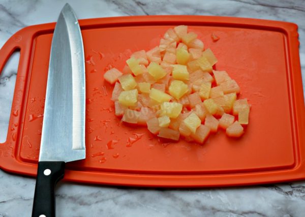 Take several pineapple rings from the jar, gently squeezing them to remove excess syrup. Cut the canned pineapple into medium-sized cubes.

