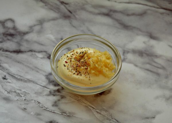 Now, prepare the salad dressing. Mix mayonnaise with spices (Italian herbs work well, or use regular ground black pepper). Add pressed garlic and blend thoroughly. You can make your own mayonnaise—recipes are available after the final step. If desired, you can replace mayonnaise with sour cream or thick, unsweetened yogurt.

