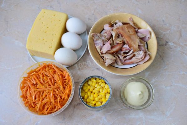 Gather the necessary ingredients for crafting a delightful salad featuring smoked chicken breast and Korean carrots. Boil the eggs for 7-9 minutes, then cool them in cold water. Open the corn jar and drain the liquid from it.

