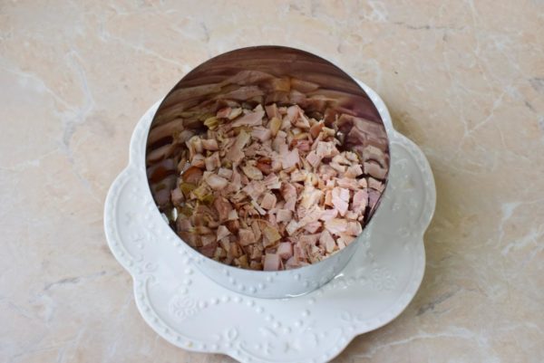 Assemble the salad in layers within a ring. Begin with a layer of chopped smoked chicken, pressing it down slightly for a denser base. Lightly coat the chicken with a small amount of mayonnaise. You can opt to prepare your own mayonnaise using the recipes provided in the link below the steps.


