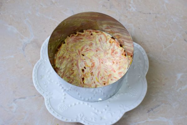 Add the chopped carrots to the next layer of the salad and apply a thin layer of mayonnaise.


