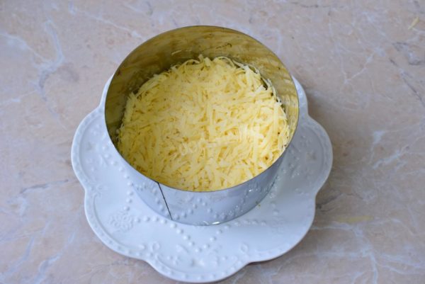 Introduce grated cheese in the third layer, using a medium or fine grater, and brush it with mayonnaise.


