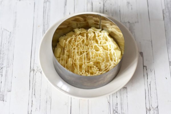 Layer all the ingredients in a salad bowl, or use a cooking ring (Ø 16-18 cm) for a visually appealing presentation. Start with the pineapples as the first layer and drizzle mayonnaise over them. Using a pastry bag with a cut tip is more convenient than a spoon.


