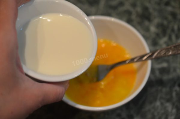 Pour in the milk, following the traditional guideline that suggests using an amount of milk equal to half the volume of one eggshell per egg. You can even use an eggshell to measure the milk accurately. Stir the mixture thoroughly with a fork.

