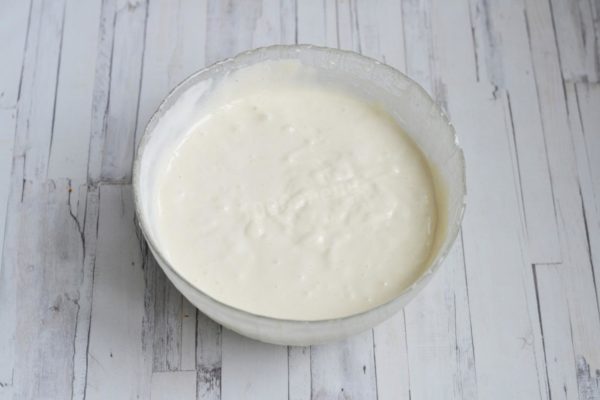 The dough should resemble thick sour cream while retaining some air bubbles, although not as many as before adding the flour.


