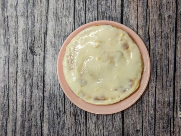 Start assembling the cake. Place one cake layer on a serving platter, spread it with cottage cheese cream, and then place the second cake layer on top. Repeat this process for the remaining layers.


