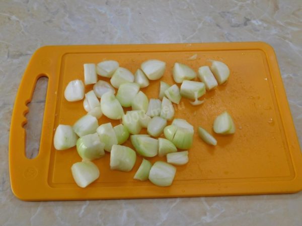 Peel the onion, rinse it, and then chop it into several pieces. To avoid onion-induced eye irritation while cutting, rinse both the onion and the knife with cold water.

