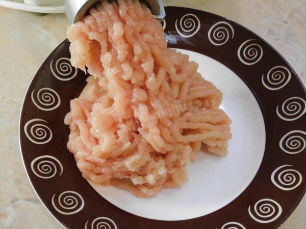 Use a meat grinder to process the chicken meat into a fine mince. Transfer the minced meat to a deep bowl. If the resulting minced meat seems dry, consider adding a bit of kefir to enhance juiciness.

