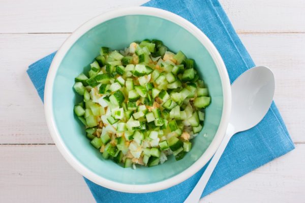 Wash the fresh cucumbers and pat them dry with paper towels. If the cucumber skin is undamaged, not tough, and not bitter, there's no need to remove it. Cut the cucumbers into small cubes and add them to the salad bowl with the rice and eggs.


