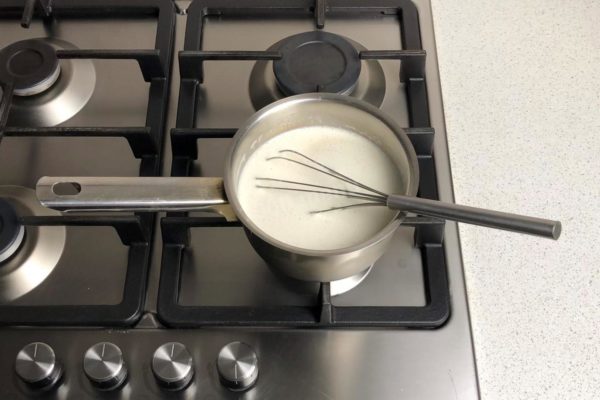 Place the saucepan over low heat. If you're unsure or don't have much experience, consider using a double boiler to cook the custard. This will extend the cooking time but prevent burning and curdling. I made the custard without a double boiler. A helpful tip is to keep the heat on the lowest setting and stir the custard constantly with a whisk to prevent issues.

