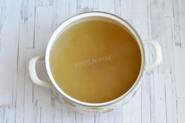 Remove the cooked meat from the pot. Discard the onion, ribs, bay leaves, and allspice, then strain the broth and return it to low heat.


