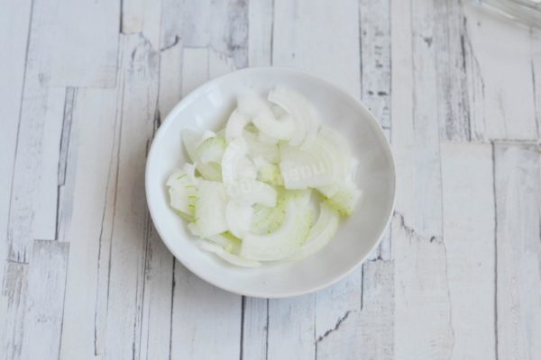 Slice the onion into small strips by first halving it, then quartering each half and cutting them into thin strips.


