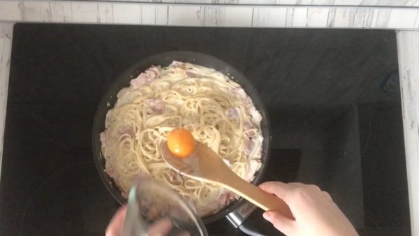 Finishing Touches: Introduce a raw egg yolk to the pasta and quickly mix to distribute it evenly. If you have concerns about using raw yolk, you can skip this step. Serve the pasta carbonara on plates, garnished with grated Parmesan cheese, fresh basil leaves, and cherry tomato slices for an exquisite presentation.
