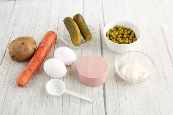How to make a classic winter salad with sausage, cucumber, and peas? Gather the necessary ingredients. If desired, you can add onions. Remove the marinade from the green peas.

