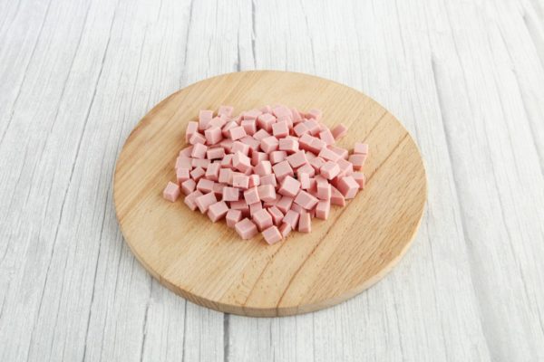 Cut the sausage into cubes in the same way as the rest of the ingredients. Choose high-quality sausage for a tastier salad.

