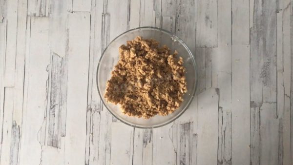 Crumble the shortbread cookies in a deep bowl, add the softened butter, and mix until it becomes a smooth mixture.



