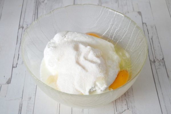 In a suitably sized container, combine the eggs and sugar. To achieve a light and fluffy casserole, use an electric mixer to beat the mixture until it forms a stable, airy foam. Then, add the mashed cottage cheese and milk. Continue beating until the mixture is smooth. You can find more details on selecting and preparing cottage cheese in the article linked at the end of the recipe.

