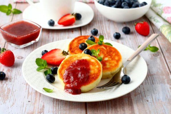 Serve the cottage cheese pancakes with sour cream and your choice of sweet toppings, such as jam, fruit preserves, or condensed milk. Enjoy your meal!