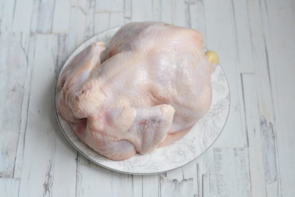 Wash the chicken thoroughly and pat it dry with paper towels. Remove any remaining feathers if present.

