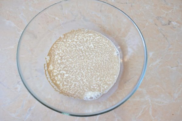 Warm the milk until it reaches a lukewarm temperature, then pour it into a mixing bowl where you'll prepare the pancake batter. Add sugar and dry yeast to the milk.

