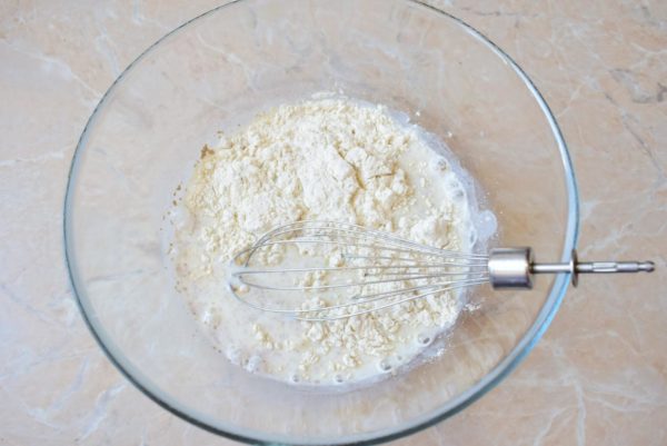 Incorporate about one-third of the flour into the mixture, creating a liquid base for the pancake batter.

