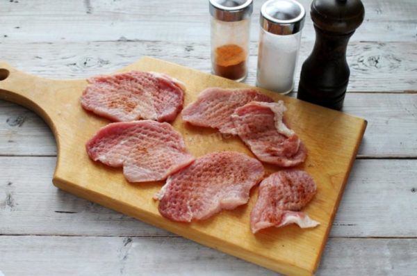 Remove the plastic wrap and season the pork chops with salt, pepper, and paprika. You can replace paprika with ready-made pork spices or choose your preferred seasonings. Herbs like Provencal, basil, marjoram, or oregano are excellent options. If time permits, marinate the meat in the refrigerator for a couple of hours to enhance its flavor.


