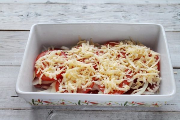 Grate hard cheese coarsely and generously sprinkle it over the tomato layer. The more cheese you use, the more flavorful it will be. Russian, Edam, or Adyghe cheese varieties work well. Make sure your cheese is of high quality, delicious, and fragrant. Since the cheese should be baked in this dish, it's best to add it before cooking. However, if you prefer it to melt, add it 15 minutes before the cooking time ends.


