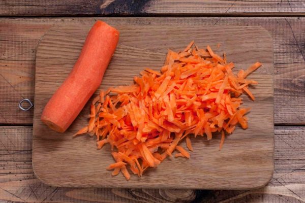 Rinse the carrots under cold running water and peel them. Grate the peeled carrots using a coarse grater.


