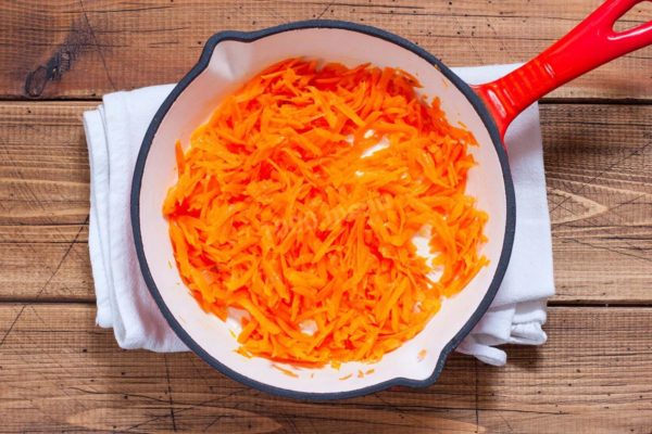 In a preheated frying pan, add vegetable oil and place the grated carrots in it. Sauté the carrots over medium heat, stirring occasionally, for approximately 10 minutes. Keep the pan uncovered.


