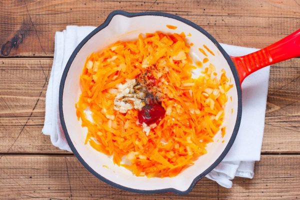 Reduce the heat slightly and add the minced garlic, tomato paste, salt, and ground black pepper to taste. You can also incorporate your favorite spices or dried herbs. Mix everything thoroughly. Continue sautéing the carrots until they are fully cooked, which should take about 15 minutes.


