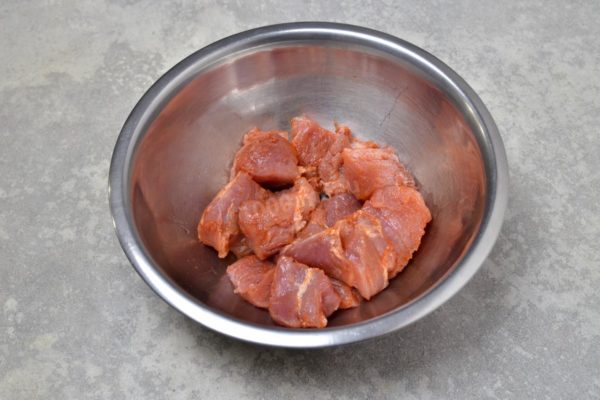 Place the meat pieces in a bowl and season them with your chosen spices. I recommend using sweet paprika and ground black pepper. Hold off on adding salt at this stage, as it can draw moisture out of the meat while frying. Drizzle a bit of vegetable oil over the meat and mix everything together. Ideally, let the meat marinate for an hour to enhance its flavor, but if you're short on time, you can proceed immediately.

