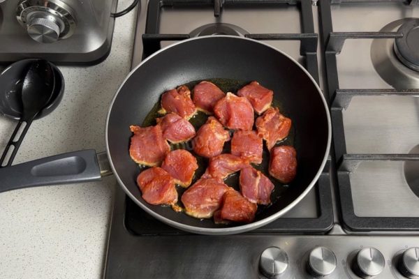 Preheat a frying pan over high heat. To ensure your meat stays juicy while frying, it's essential to select the right frying pan with a thick bottom and a non-stick coating. Maintain high heat throughout the cooking process. Add cooking oil to the hot pan. Arrange the meat pieces in a single layer to avoid stewing them. For more information on choosing the right frying pan and oil, refer to the articles linked at the end of the recipe.

