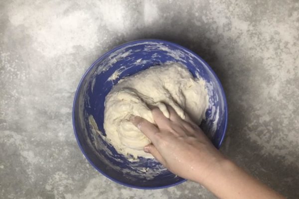 Continue kneading the dough with your hands. While you can use a mixer, we're making bread without an oven, so let's use our hands. Keep adding flour, but do so gradually. Observe the dough; it should not be too liquid but should not be too firm either. Stop kneading as soon as the dough starts to come off your hands. I used more than 500 grams of flour, but your requirement may differ.


