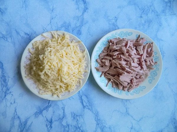 Cut the sausage into strips, which is the standard slicing for homemade pizza. Grate the cheese coarsely.


