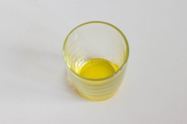 Begin by pouring a layer of vegetable oil into a transparent glass or jar. This will prevent the mustard powder from sticking to the bottom while you mix. Using a transparent container aids in better mixing since you can easily see any dry powder remaining.



