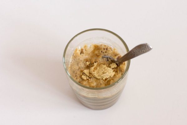 Gradually pour in warm (not hot!) water. Take your time, adding a bit at a time and stirring in between. Mustard powder absorbs water readily, so add just enough to achieve a consistency similar to that of not-too-thick sour cream. Ensure there are no dry spots left in the glass.


