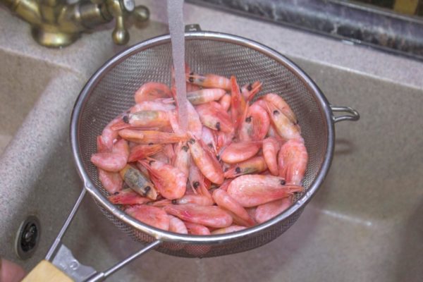 Take a saucepan and fill it with an appropriate amount of water. You'll need at least 2 liters of water for every 1 kilogram of shrimp. Rinse the shrimp under warm water to remove any excess dirt, broken antennae, and ice.

