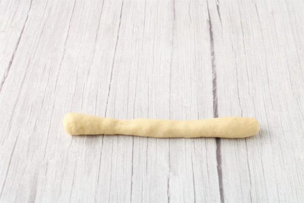 Roll out each piece of dough into a 20-24 cm long strip, making the middle slightly thinner than the edges.


