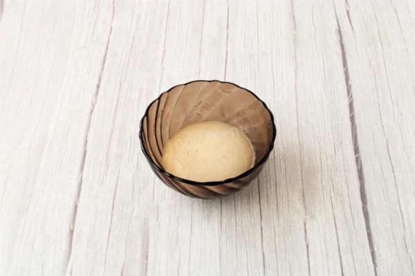 In a small bowl, combine the yeast, 1 teaspoon of sugar (from the total amount), and approximately 50 ml of slightly warm water. Stir and let it sit for 10-12 minutes to activate the yeast. A foamy "cap" should form on the surface, indicating good yeast quality. If the yeast doesn't rise or rises inadequately, it's better to replace them. Otherwise, the dough won't rise well, and the baking won't be successful.



