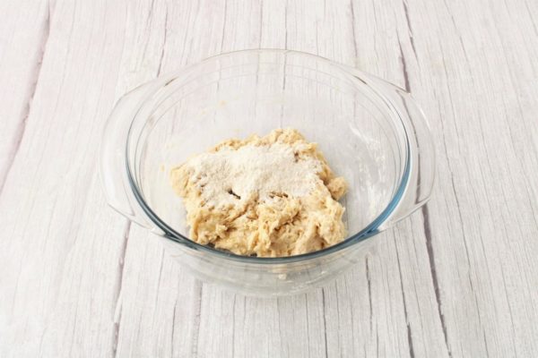 Continue adding the remaining flour in small portions while stirring the dough and monitoring its consistency.


