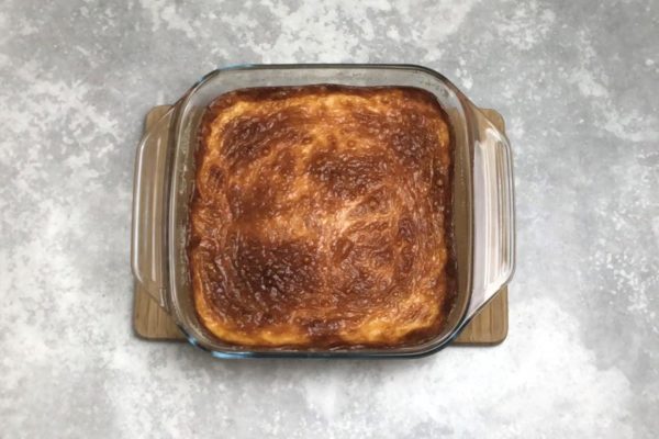 Bake the casserole in an oven preheated to 180°C in the top-bottom mode for approximately 30-40 minutes, or until the top becomes golden brown. To check if it's done, insert a skewer into the casserole at multiple points; if it comes out dry, the casserole is ready. Allow the finished casserole to cool completely before removing it from the mold.

