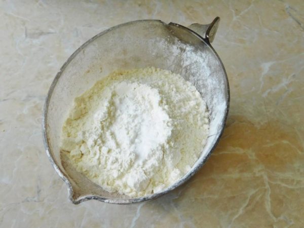Sift the flour through a sieve and add vanilla extract and baking powder to it. Sifting will aerate the flour, resulting in an even fluffier and tender cake.

