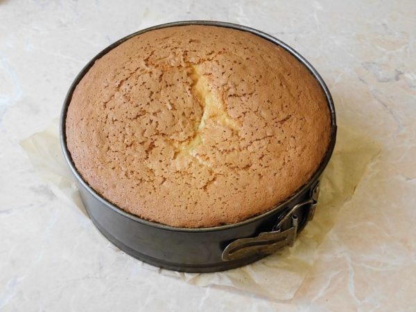 To check if the cake is done, gently press it on top. If it springs back to its original shape, it's ready and can be taken out of the oven. Alternatively, use a toothpick: insert it into the center of the cake and remove it – if it comes out dry, the cake is ready. Run a sharp knife around the edges of the cake to loosen it from the sides of the pan, and then remove it.

