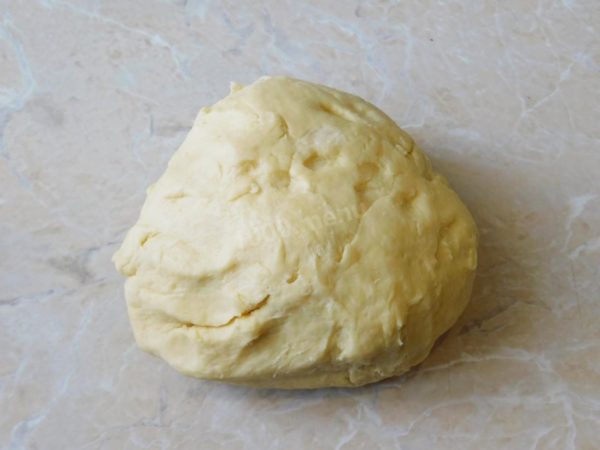 Continue kneading the dough by hand until it no longer sticks to your hands. You don't need to knead it for an extended period. As soon as it has absorbed the additional flour and no longer sticks, stop kneading. Over-kneading can result in a very dense and dry finished product.

