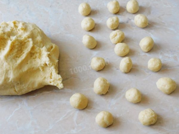 Pinch off small balls from the prepared dough, slightly smaller than a walnut. It's convenient to roll out many balls at once and then start baking them. The key is to put the right number of balls into the mold all at once.

