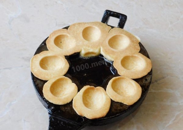 You'll need a specialized mold for making nut-shaped cookies on a stovetop. Preheat it thoroughly. It's a good idea to warm up the mold before you begin kneading the dough, as it can be quite thick and take some time to heat up. Despite the presence of butter in the dough, make sure to grease the mold generously with vegetable oil before using it for the first batch. Place the dough balls in one half of the mold and press the other half on top.

